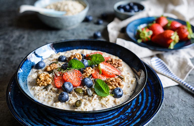 Nutritious Bircher muesli with strawberries, blueberries, chia seeds, walnuts, sunflower seeds and pumpkin seeds