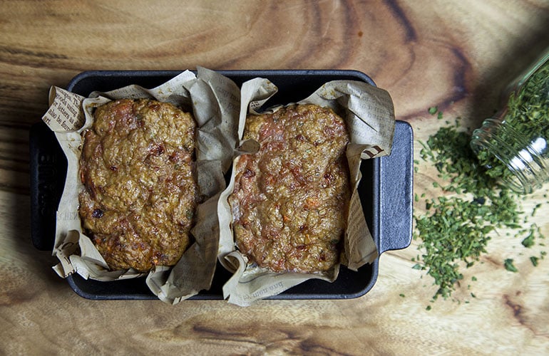 High angle view of two meatloafs on wax papers in a loaf pan