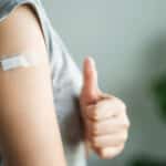 photo of someone giving a thumbs up after receiving a flu shot