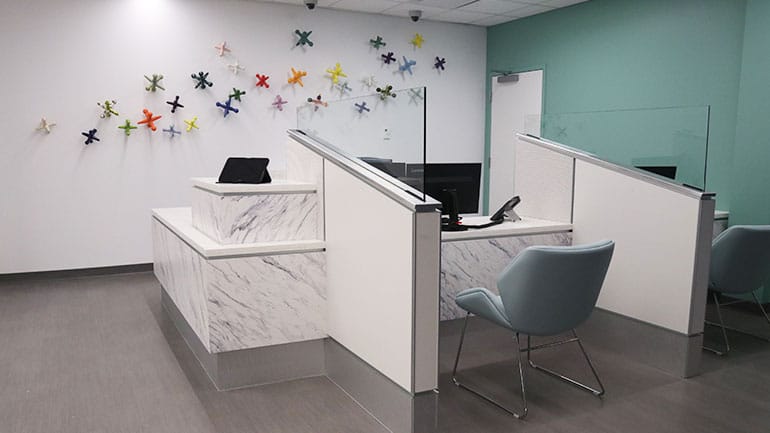 Waiting room with registration desk and large colorful jacks on the wall