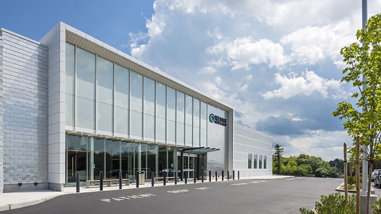 Exterior of a large glass sided building on a sunny day