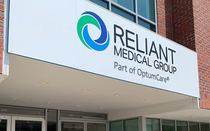 Awning in front of a brick building with Reliant Medical Group logo on a white background